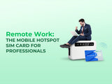 A professional man celebrating his work on a laptop while sitting on a giant mobile hotspot.