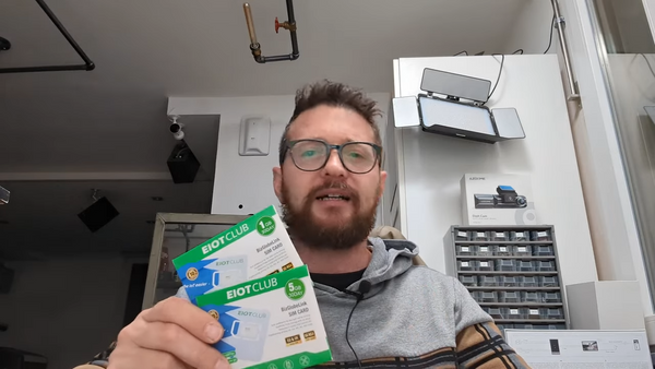 A man holding two eiotclub sim cards
